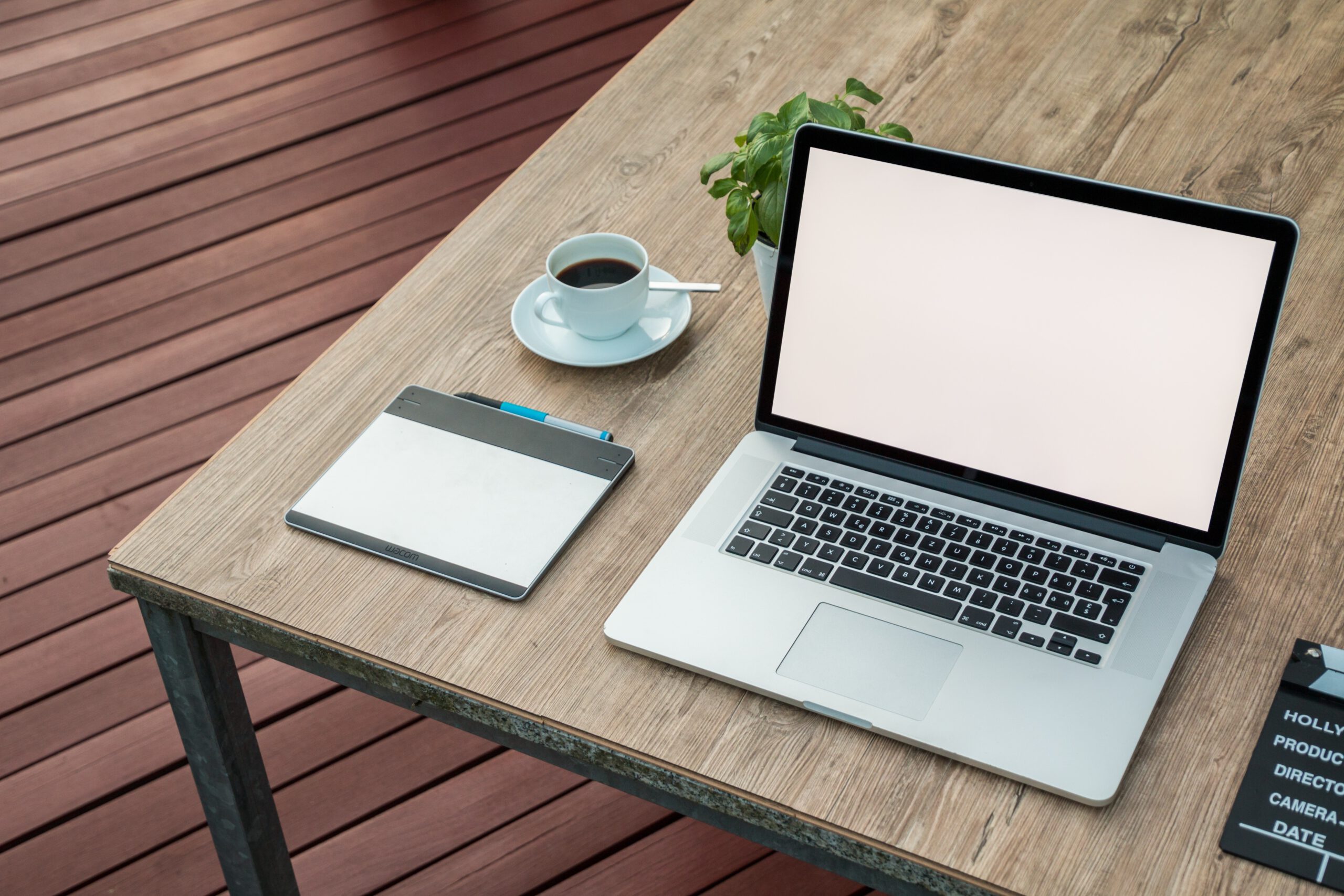 Otwarty laptopm i kubek z kawą na drewnianym stole